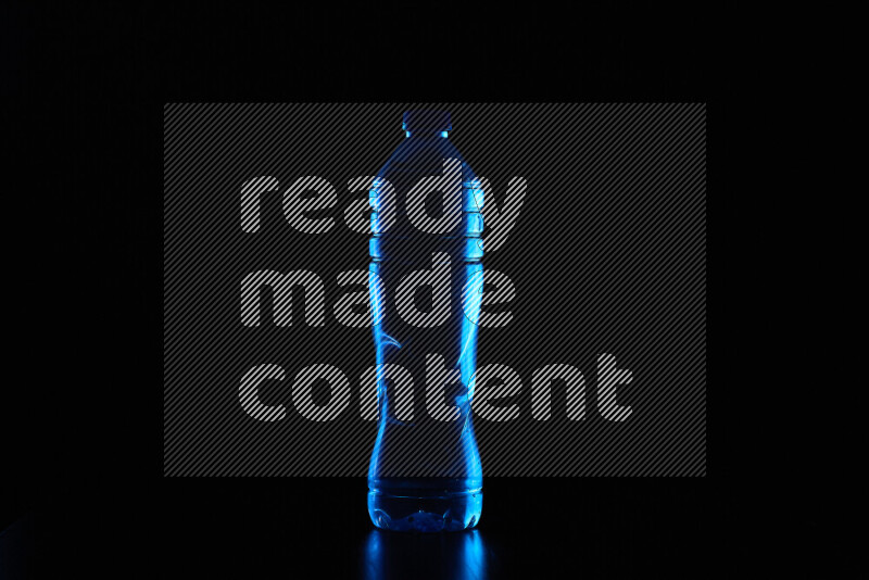 Water bottle with colored rim light against black background