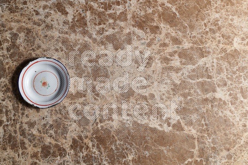 Top View Shot Of A Vintage Metal Plate On beige Marble Flooring