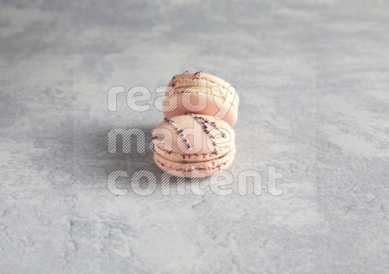 45º Shot of two pink orange blossom macarons  on white  marble background