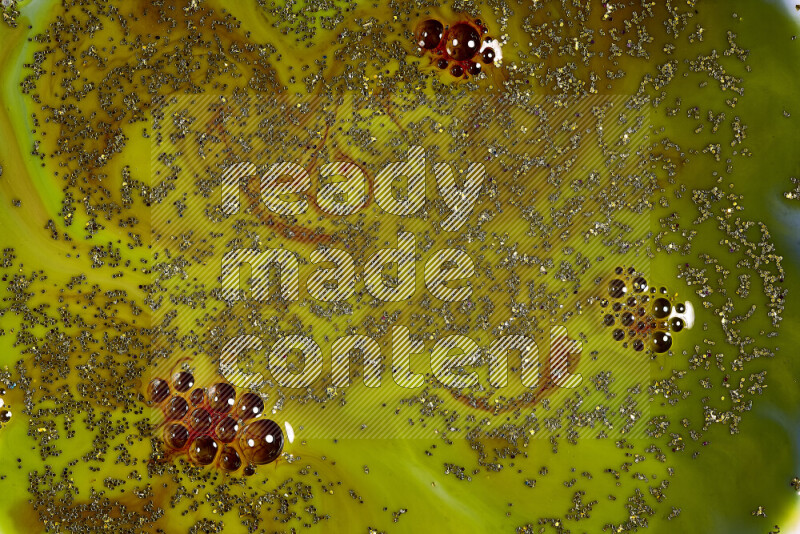 لقطة مقربة لبريق ذهبي متلألئ منتشر على خلفية من اللون الأخضر والأحمر في حركات دائرية