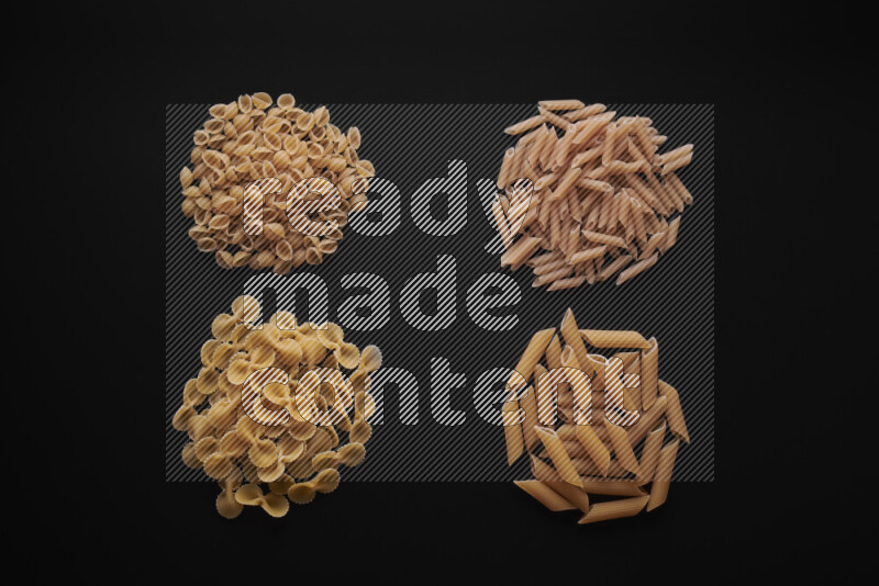 Different pasta types in bunches on black background