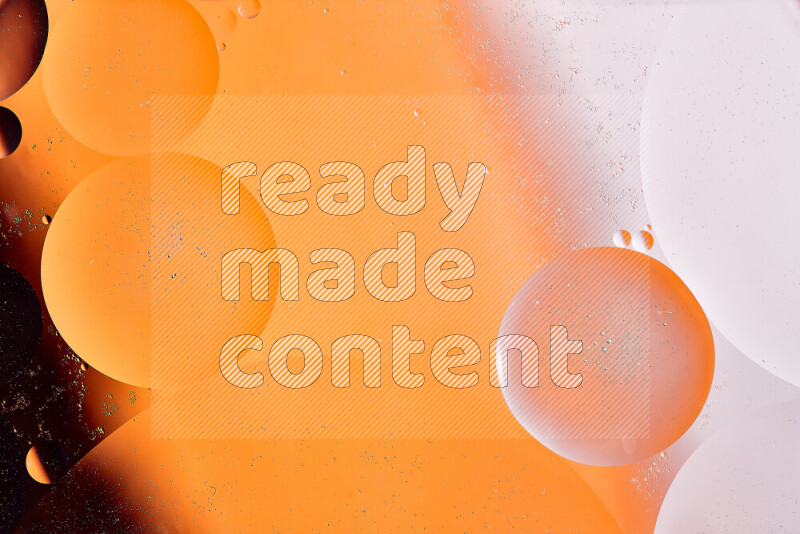 لقطات مقربة لفقاعات من الزيت على سطح الماء باللون الأبيض والبرتقالي