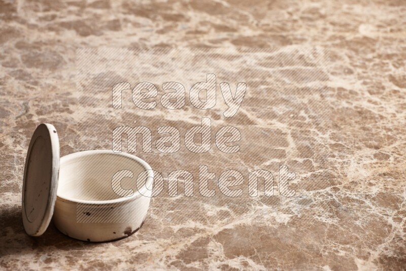 A white pottery bowl on beige marble background