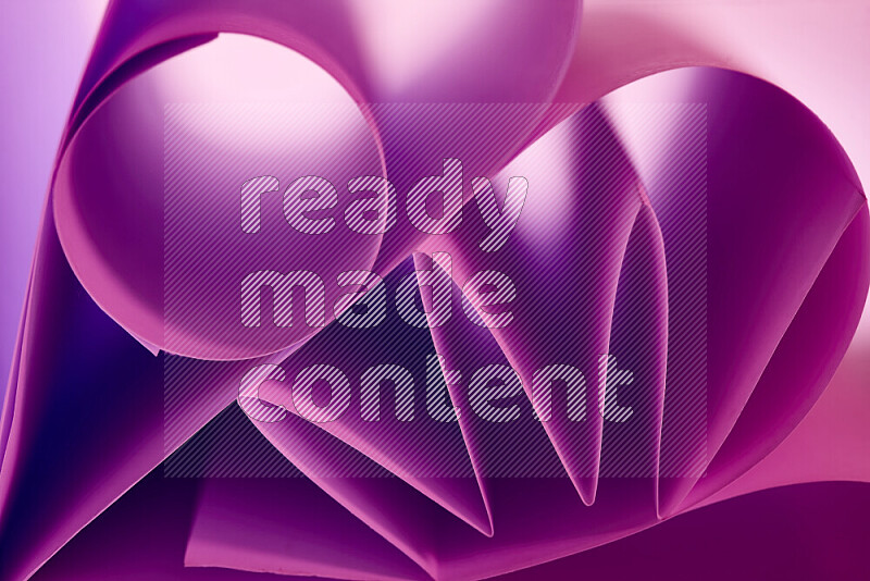 An artistic display of paper folds creating a harmonious blend of geometric shapes, highlighted by soft lighting in purple tones