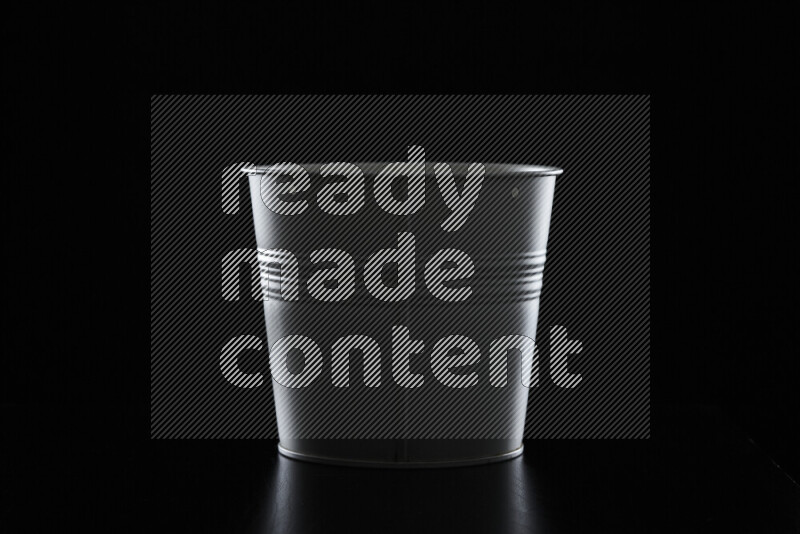 A plant pot with colored rim light against black background