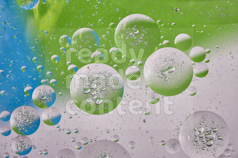 Close-ups of abstract oil bubbles on water surface in shades of white, green and blue