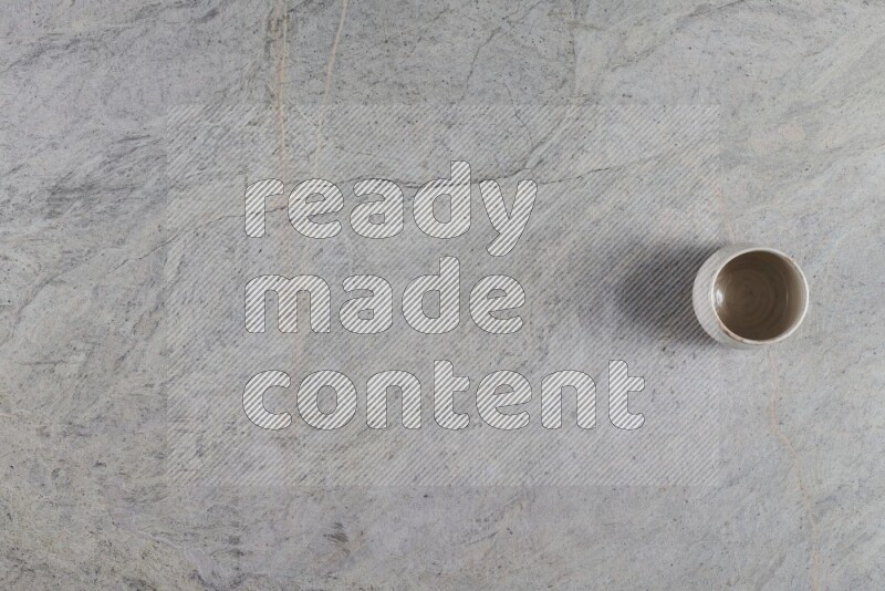 A multicolored pottery Cup on grey marble background