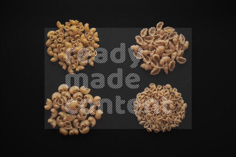 Different pasta types in bunches on black background