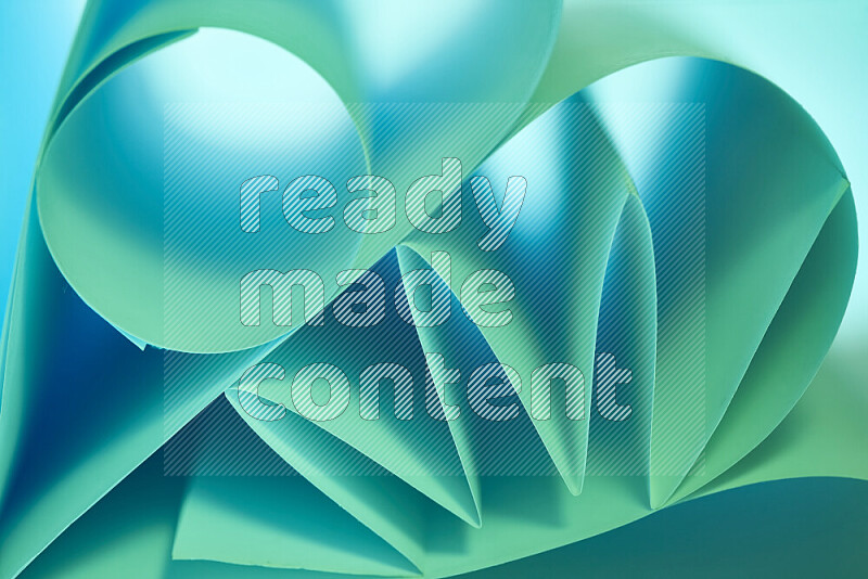 عرض فني لطيات الورق تخلق مزيج من الأشكال الهندسية، مضاءة بإضاءة ناعمة بدرجات اللون الأخضر والأزرق