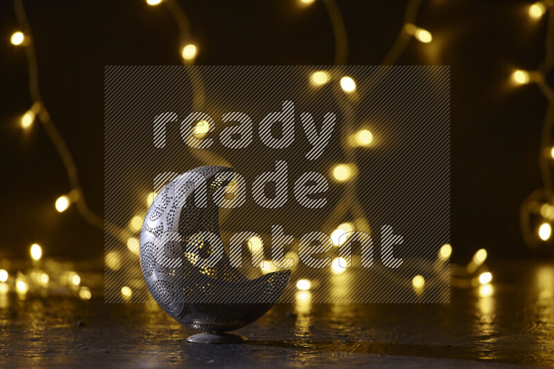 A traditional ramadan lantern surrounded by glowing fairy lights in a dark setup