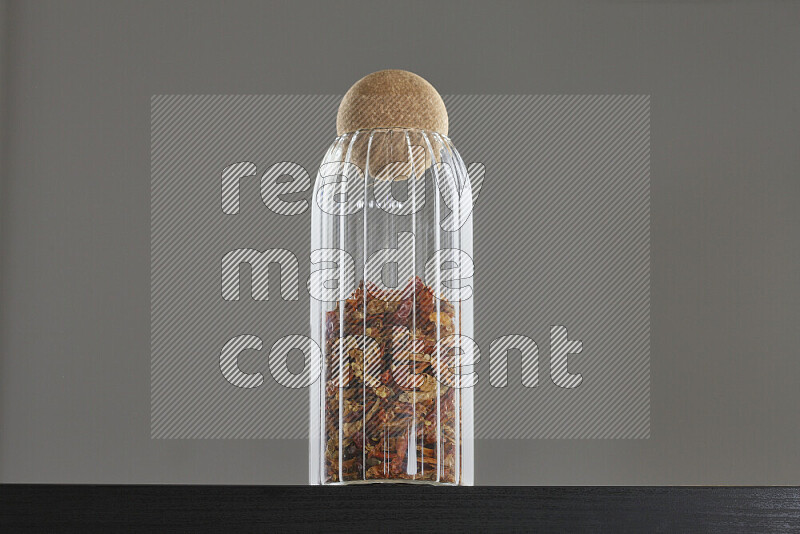 Chili pepper in a glass jar on black background