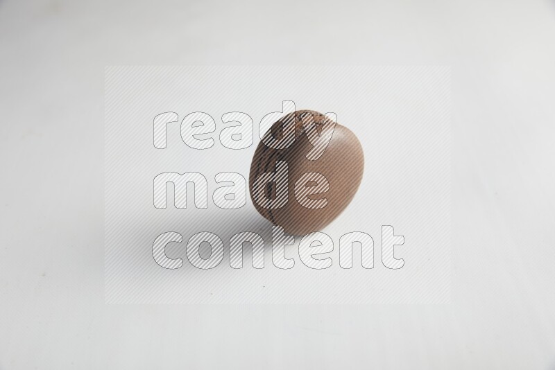 45º Shot of Brown Dark Chocolate macaron on white background