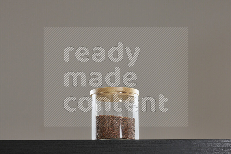 Flax seeds in a glass jar on black background