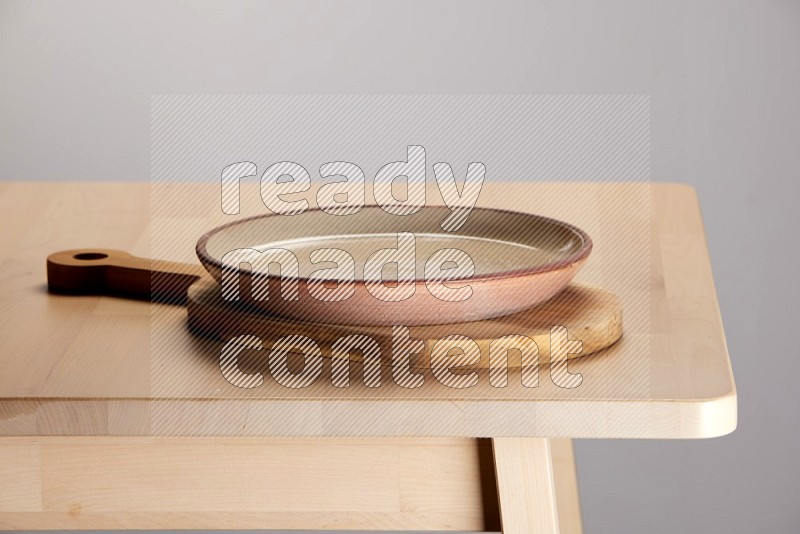 multi colored plate placed on a  wooden oval cutting board on the edge of wooden table