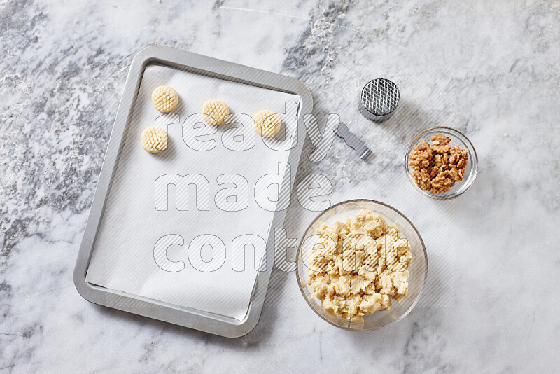 Kahk step by step with its ingredients ghee, sugar, flour, sesame, yeast, water and kahk flavor on grey marble background