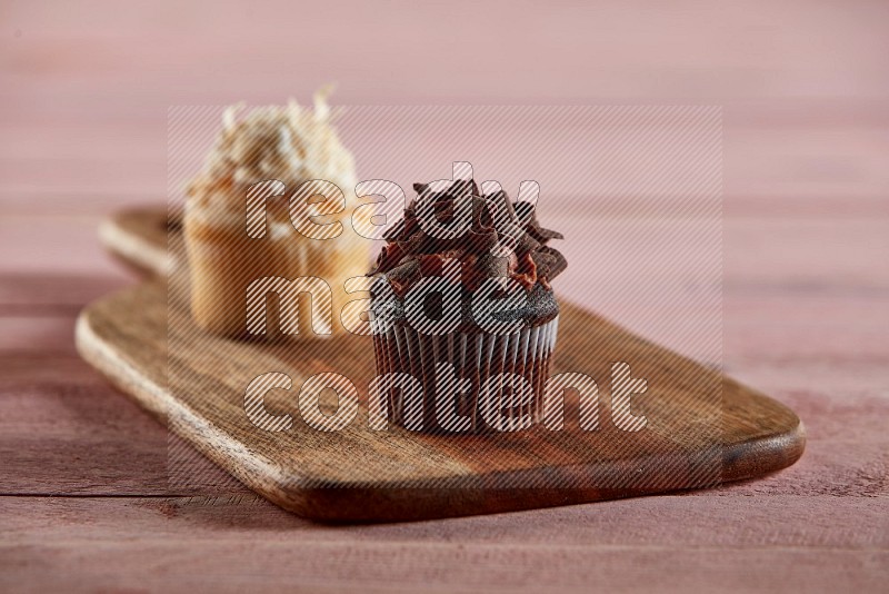 Chocolate mini cupcake topped with chocolate curls on a wooden board