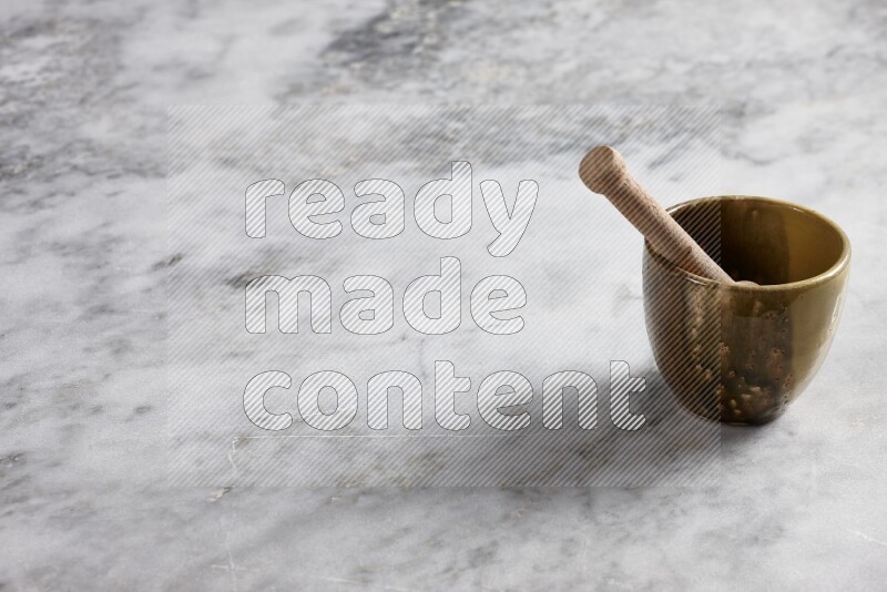 Multicolored pottery cup with wooden honey dipper in it on grey marble background