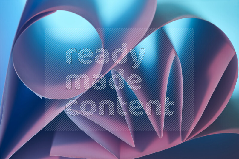 An artistic display of paper folds creating a harmonious blend of geometric shapes, highlighted by soft lighting in blue and pink tones