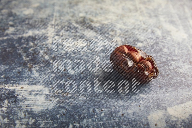 hazelnuts stuffed majdoul date on a rustic blue background