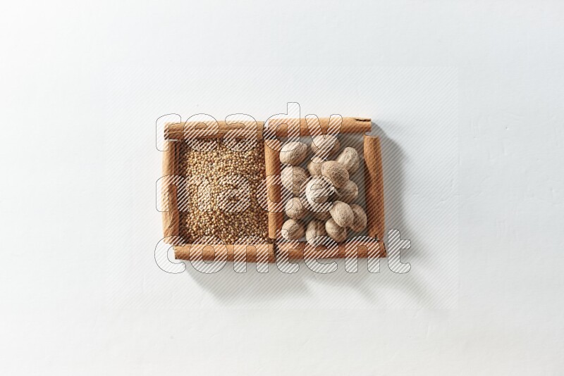2 squares of cinnamon sticks full of mustard seeds and nutmegs on white flooring