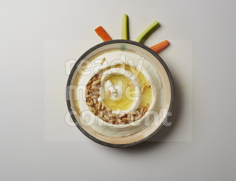 Lebnah garnished with pine nuts in a pottery plate on a white background