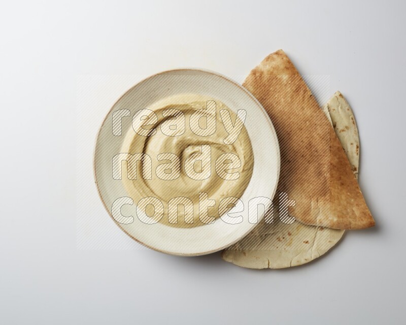 plain Hummus in a pottry plate  on a white background