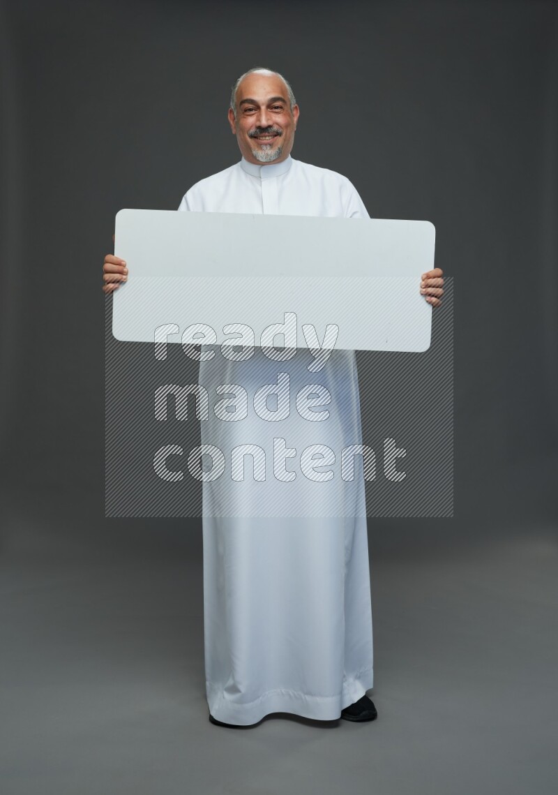 Saudi man without shomag Standing holding social media sing on gray background