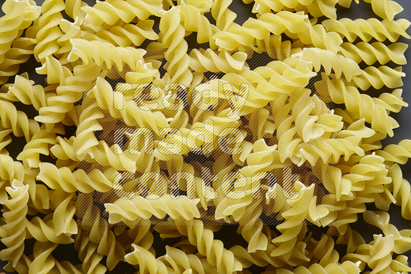 Fusilli pasta on grey background