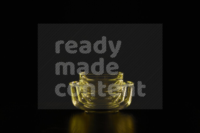 Glassware with rim light in yellow against black background