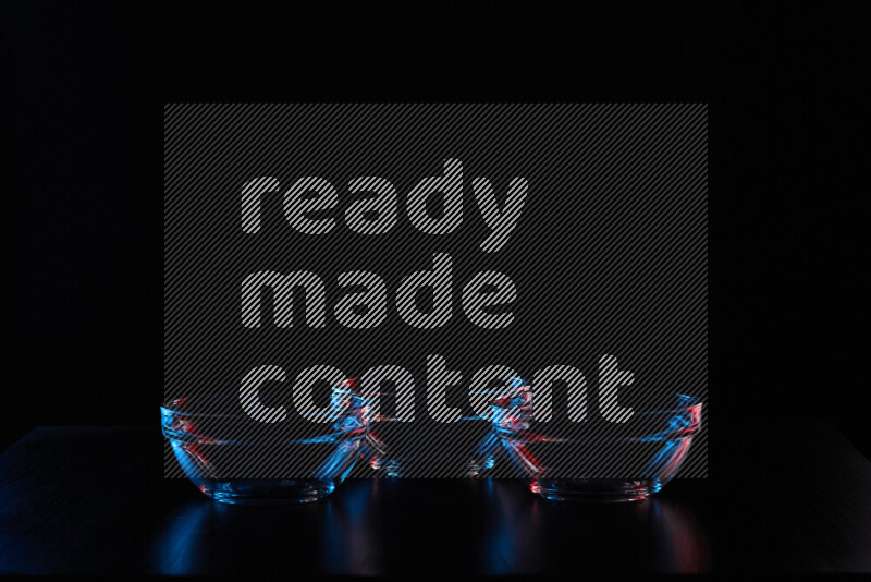 Glassware with rim light in red and blue against black background