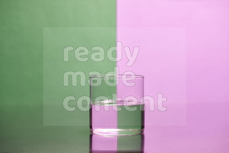 The image features a clear glassware filled with water, set against green and light purple background