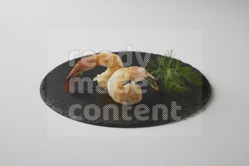 two grilled shrimp  on a black slate direct  on a white back ground