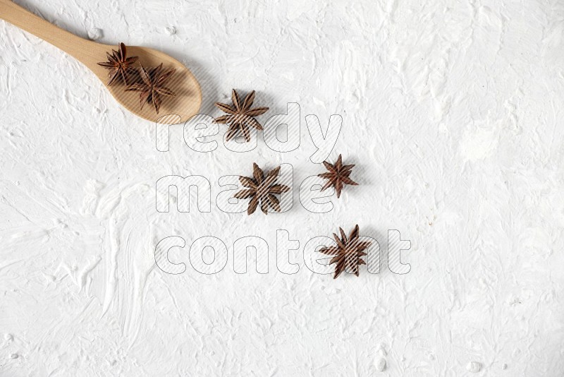 Star Anise in a wooden spoon on white flooring