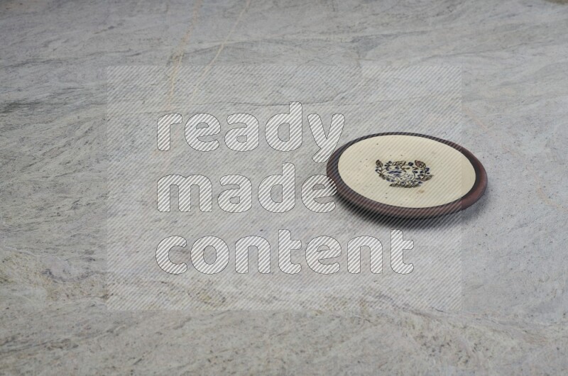 A decorative pottery plate on grey marble background
