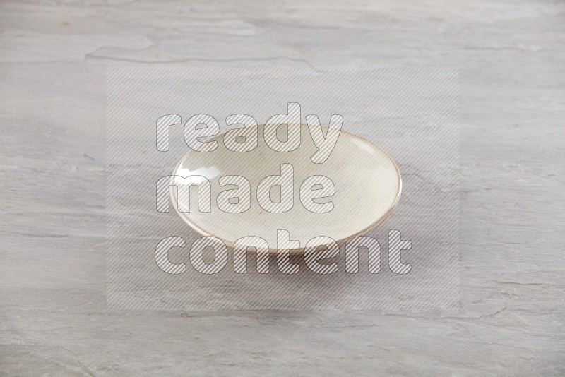 beige ceramic round plate on grey textured countertop