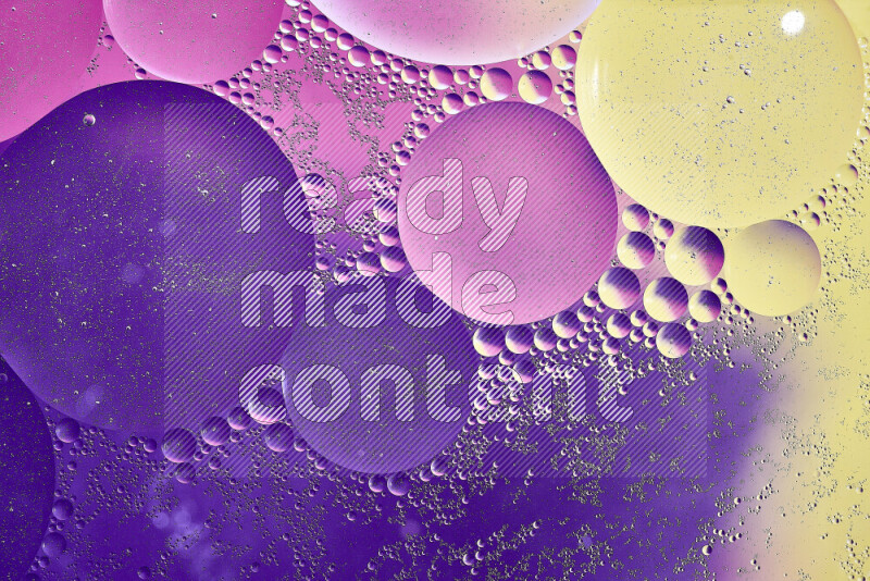 Close-ups of abstract oil bubbles on water surface in shades of yellow, purple and pink