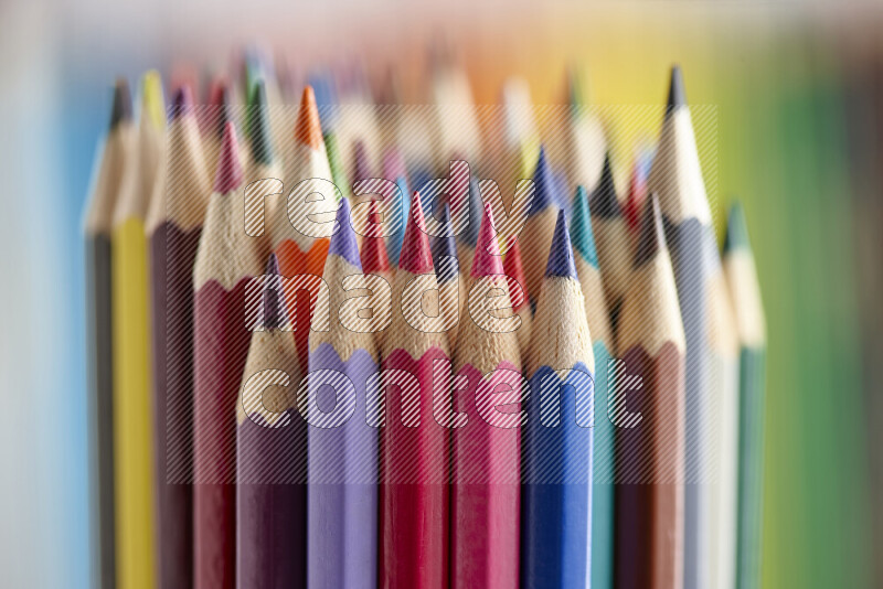 The image captures a close-up of sharpened colored pencils on multicolored background