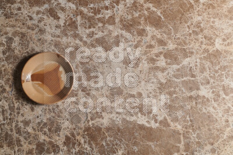 A multicolored pottery plate on beige marble background