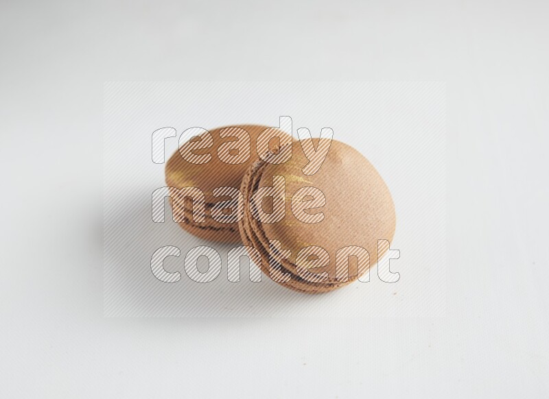 45º Shot of two Brown Coffee macarons on white background