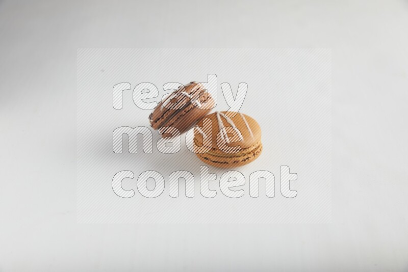 45º Shot of of two assorted Brown Irish Cream, and Brown white Chocolate Caramel macarons on white background