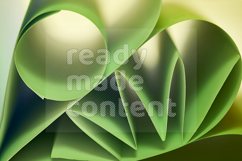 An artistic display of paper folds creating a harmonious blend of geometric shapes, highlighted by soft lighting in green tones