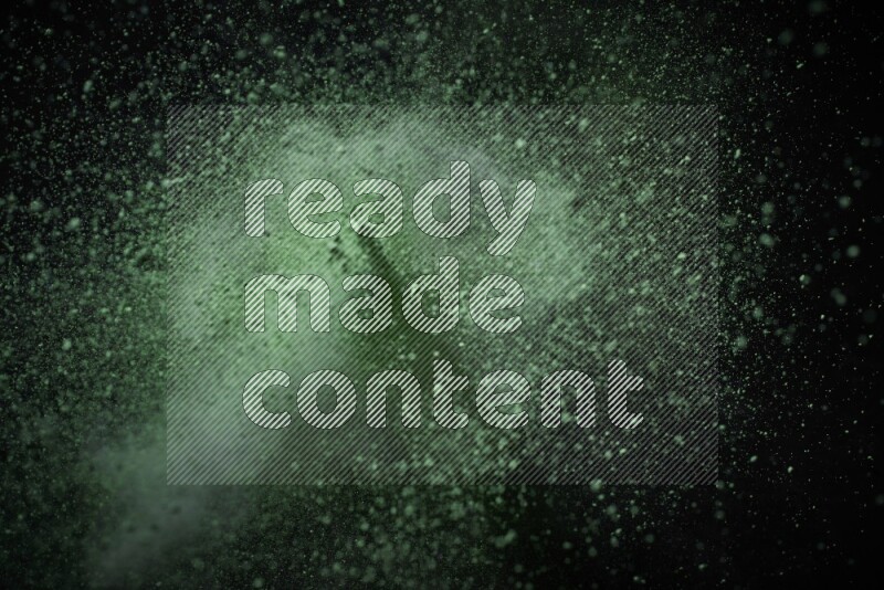 Green powder explosion on black background