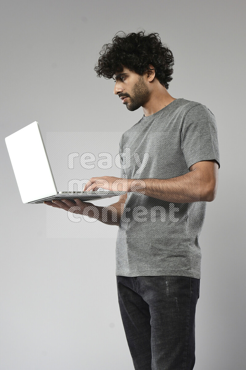 رجل يرتدي ملابس كاجوال يعمل علي لاب توب علي خلفية بيضاء