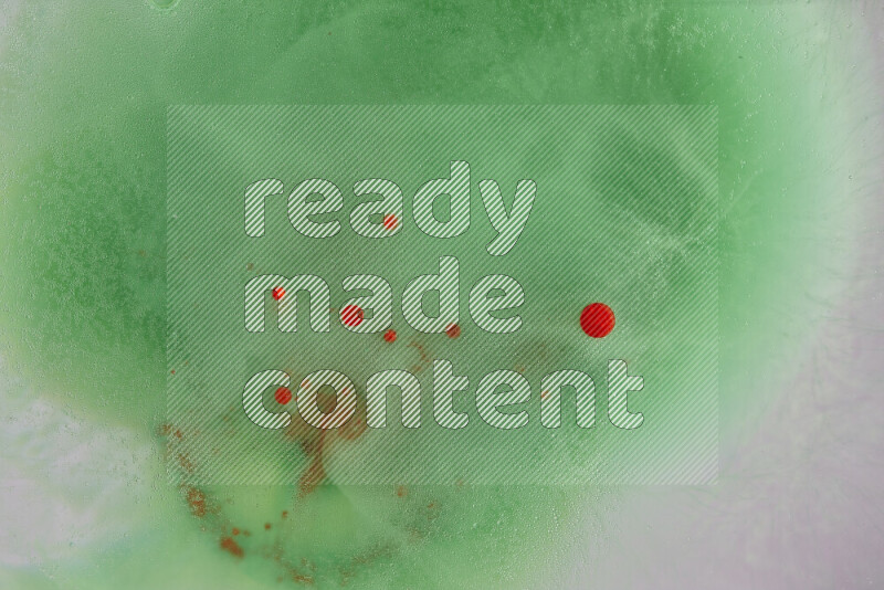 تلتقط الصورة تناثرا للطلاء الأحمر علي خلفية خضراء