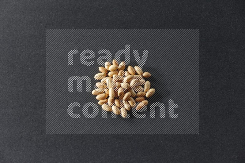 A bunch of peeled peanuts on a black background in different angles