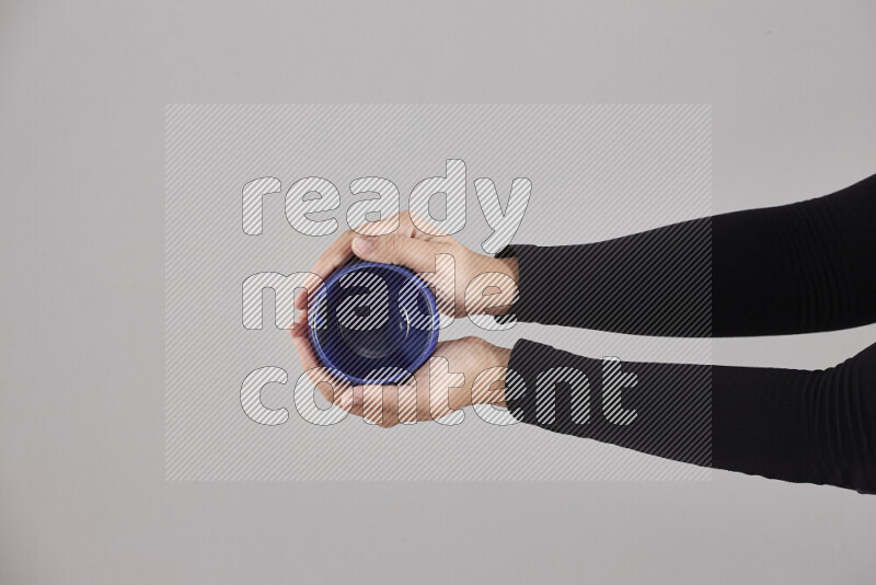 امرأة ترتدي عباءة سوداء تحمل أدوات فخارية مختلفة في أوضاع متعددة