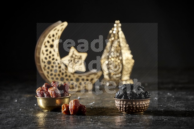 Dates in a metal bowl with dried plums beside golden lanterns in a dark setup
