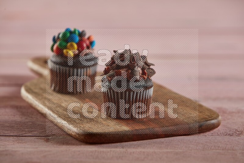 Chocolate mini cupcake topped with chocolate curls on a wooden board