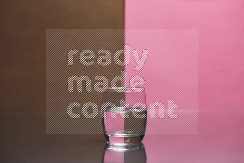 The image features a clear glassware filled with water, set against brown and pink background