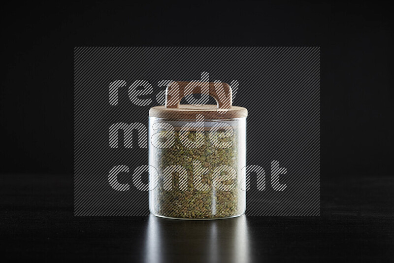 Freekeh in a glass jar on black background